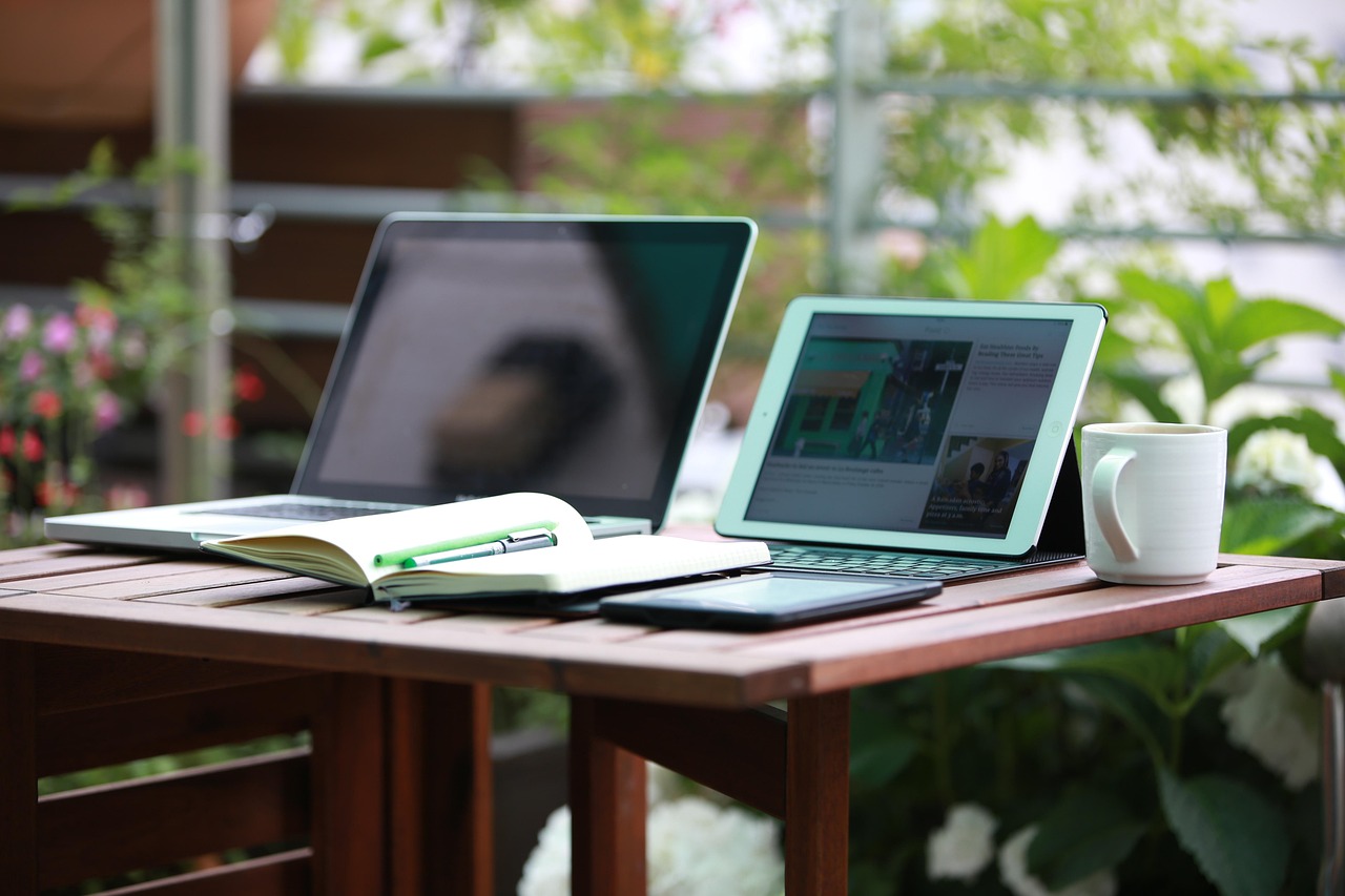Laptop op bureau in zonnig tuinkantoor.
