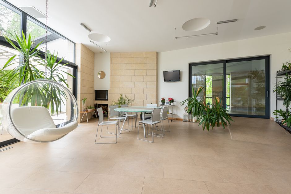 Minimalistische tuinkamer met moderne meubels en planten.